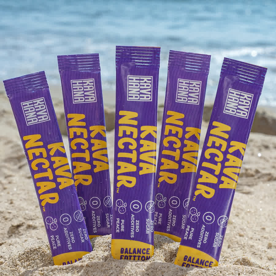 Five Kava Nectar Balance Edition stick packs standing in the sand
