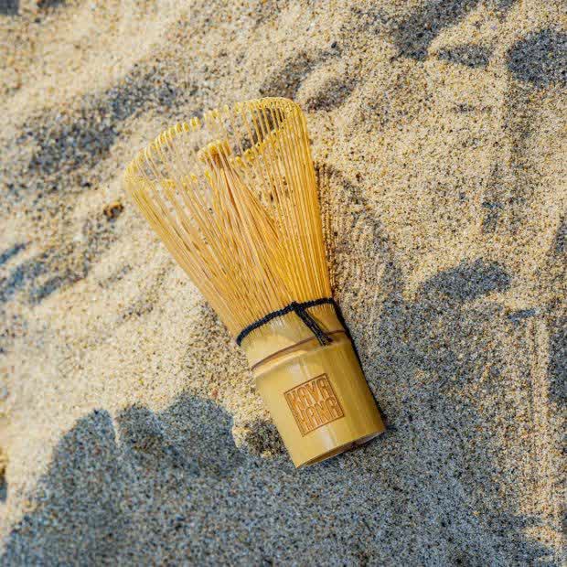 The Kavahana bamboo whisk mixing Kava Nectar in a coconut bowl